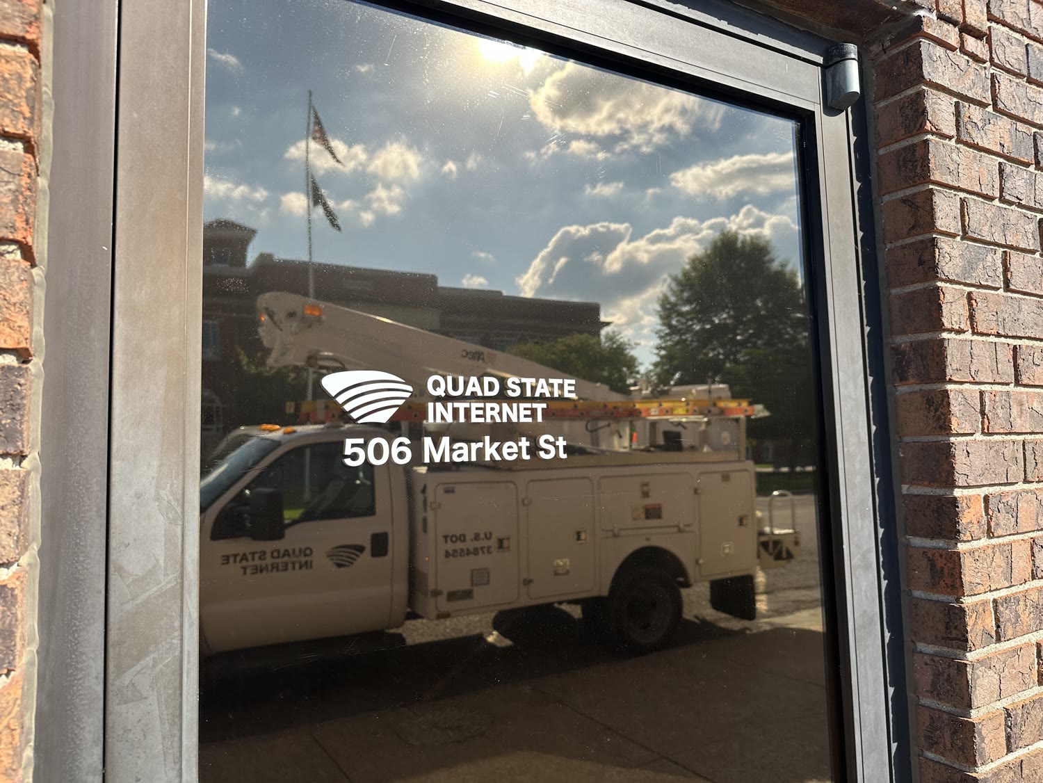 Quad State Internet's 506 Market Street location in downtown Metropolis with a field truck reflected in the window