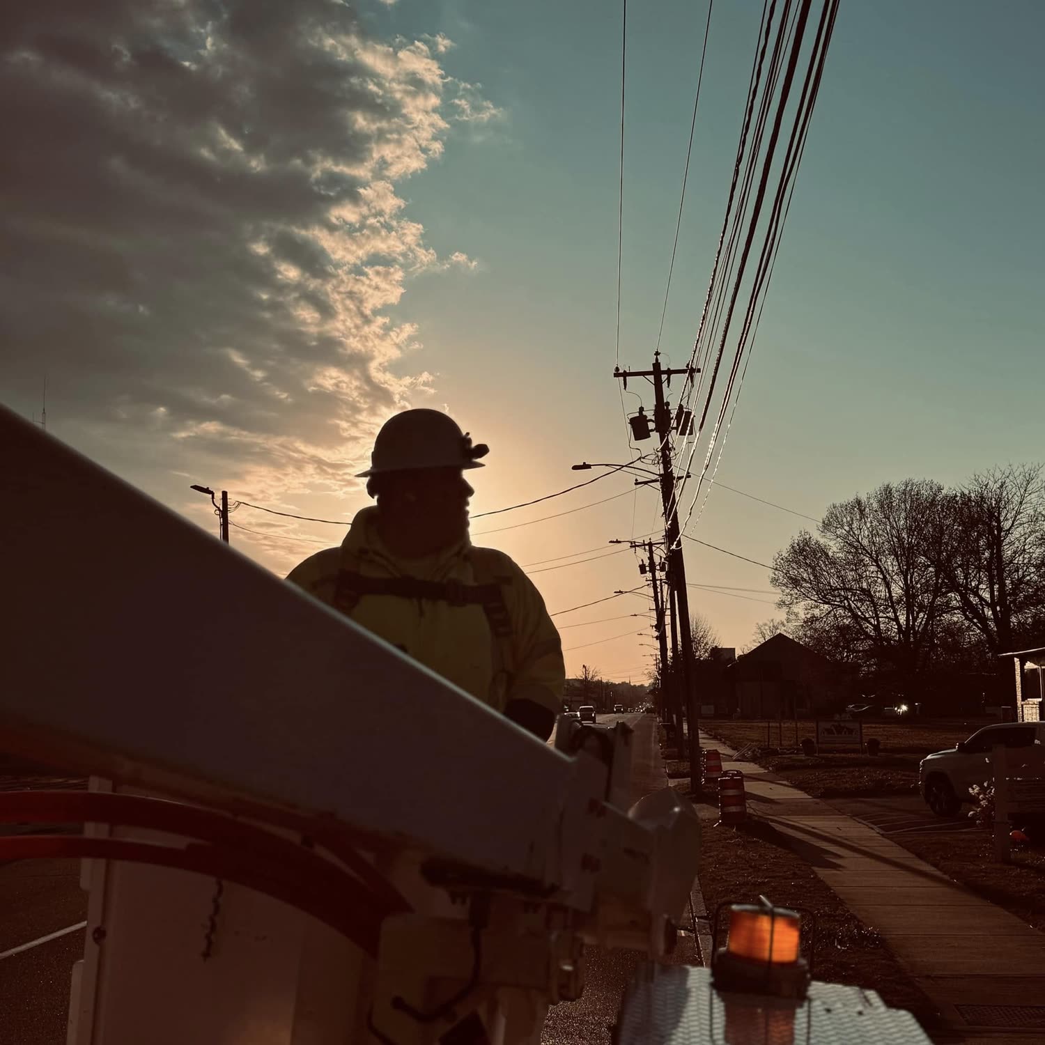 A fiber technician working at sunset