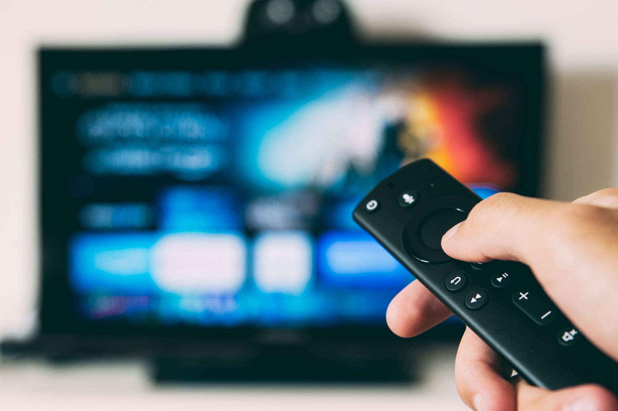 A viewer using a remote control to watch television